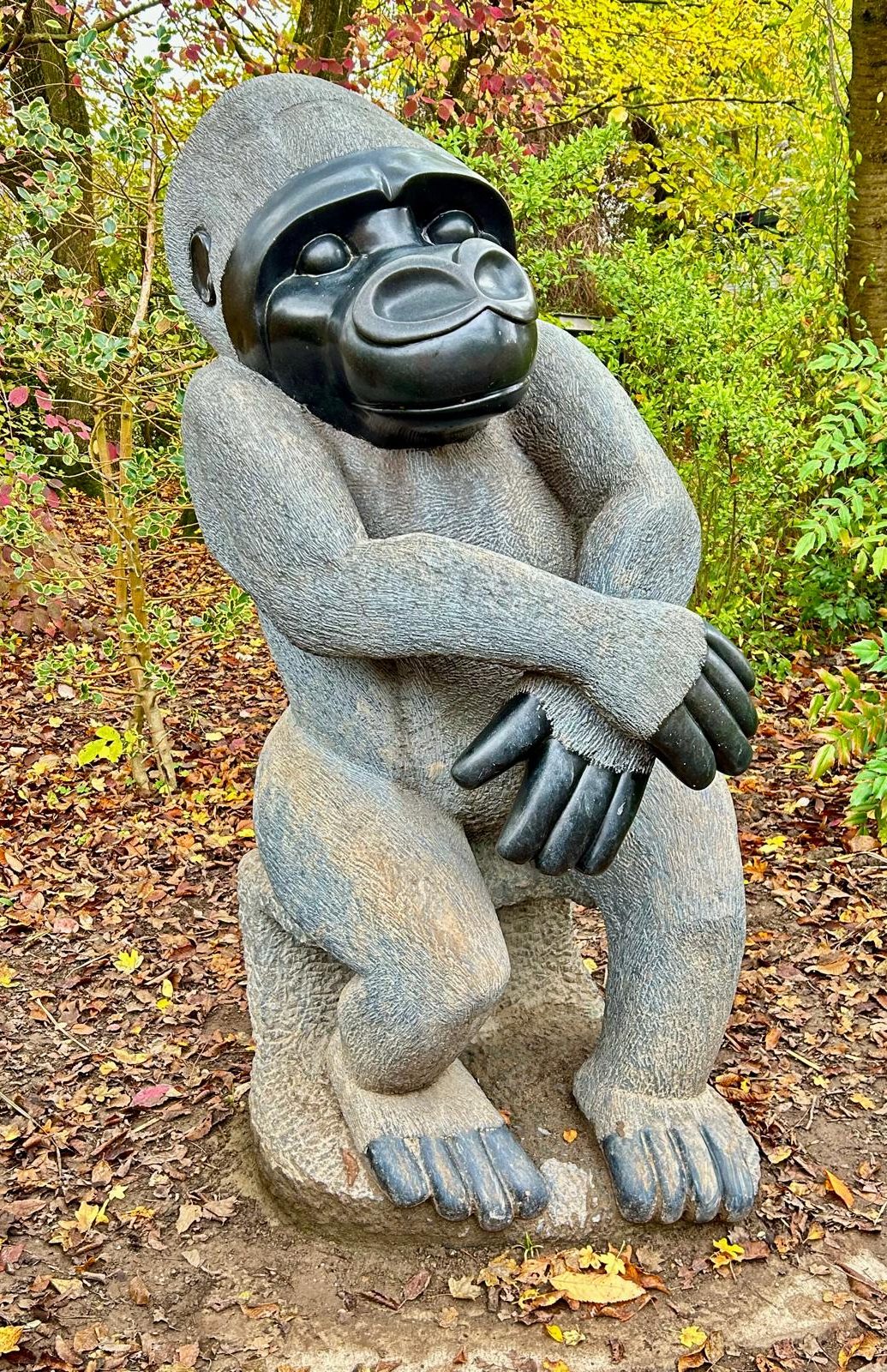 Beautifully Crafted Dark Stone Gorilla Sculpture Among Autumn Leaves