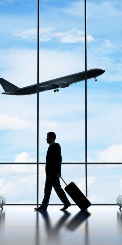 image of a man walking with his suitcase at the airport