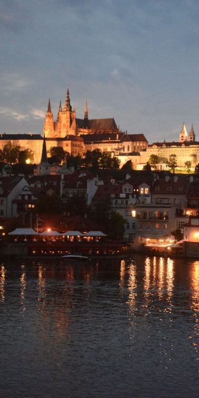 Floating boat on the Vlata river and view of Charles Bridge