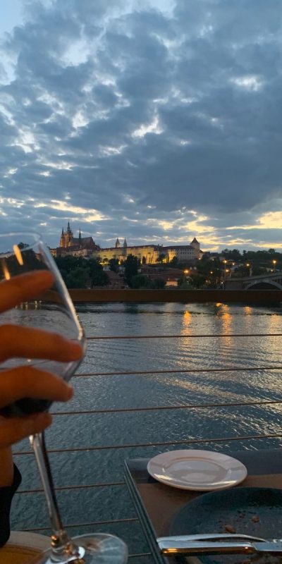 woman's hand raising a toast in front of the vlata river